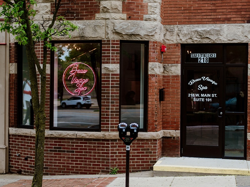 a sign on a brick sidewalk in front of a building