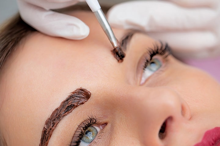 a close up of a person holding a tattoo on his head